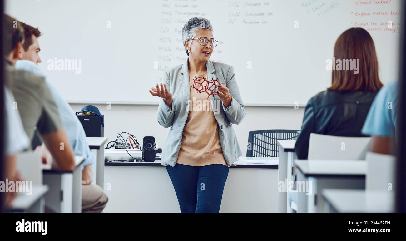 Istruzione, professore universitario e studenti in aula per lezioni sull'innovazione in scienza, fisica o matematica. Focus, attenzione e college donna Foto Stock