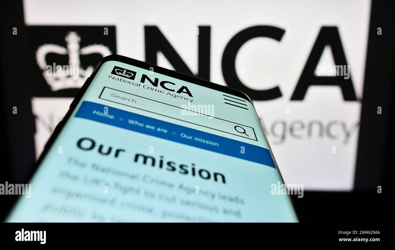 Smartphone con pagina Web della British National Crime Agency (NCA) sullo schermo davanti al logo. Messa a fuoco in alto a sinistra del display del telefono. Foto Stock