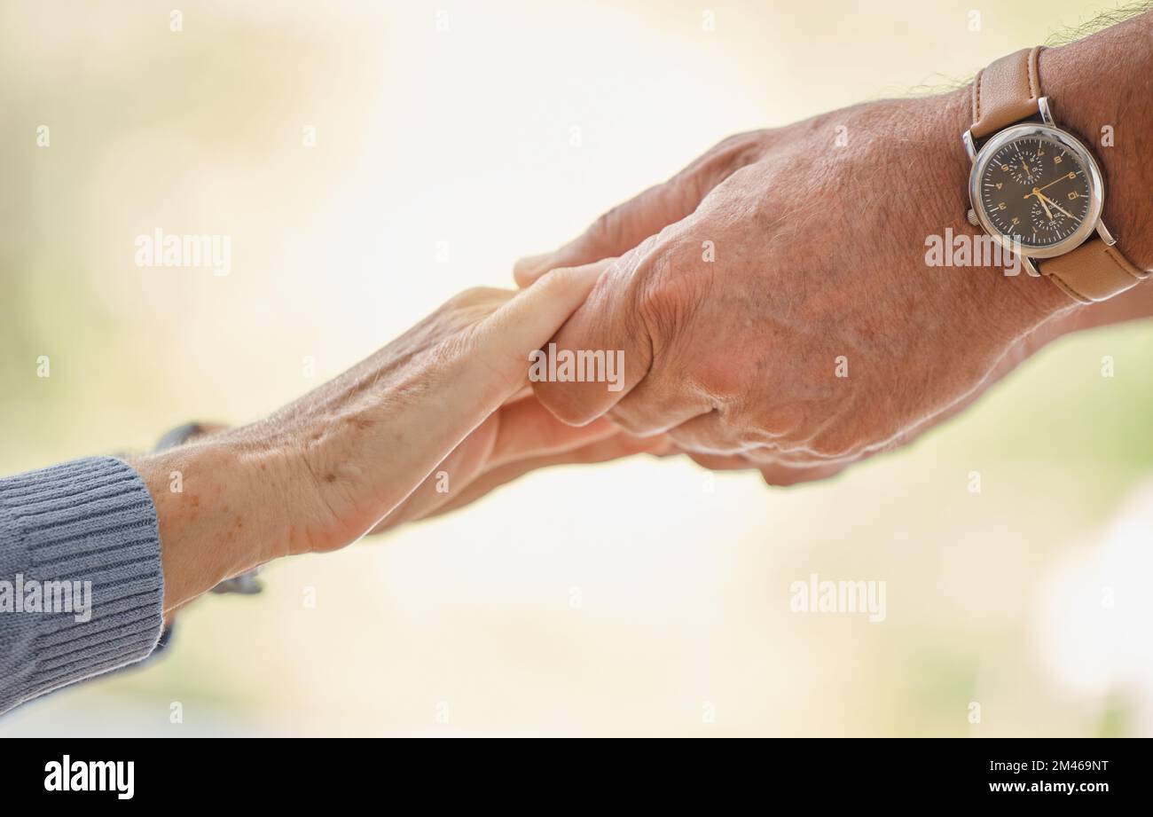 Tenere le mani, il sostegno e la fiducia con la coppia anziana, l'amore e la solidarietà con le mani di aiuto e la collaborazione all'aperto. Aiuto, impegno e fede Foto Stock