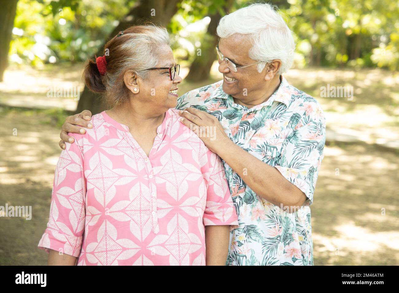 Felice coppia indiana senior guardando l'un l'altro trascorrere il tempo insieme al parco estivo. Foto Stock