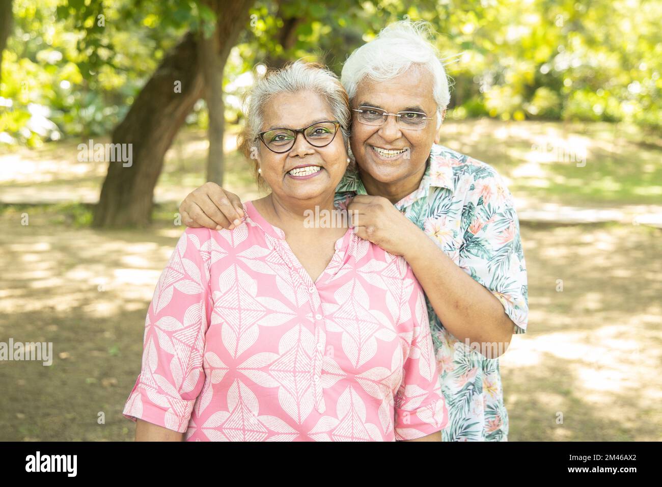 Ritratto di coppia anziana indiana felice al parco estivo. Vecchio uomo asiatico e donna in piedi all'aperto sorridente. vita di pensionamento, Foto Stock