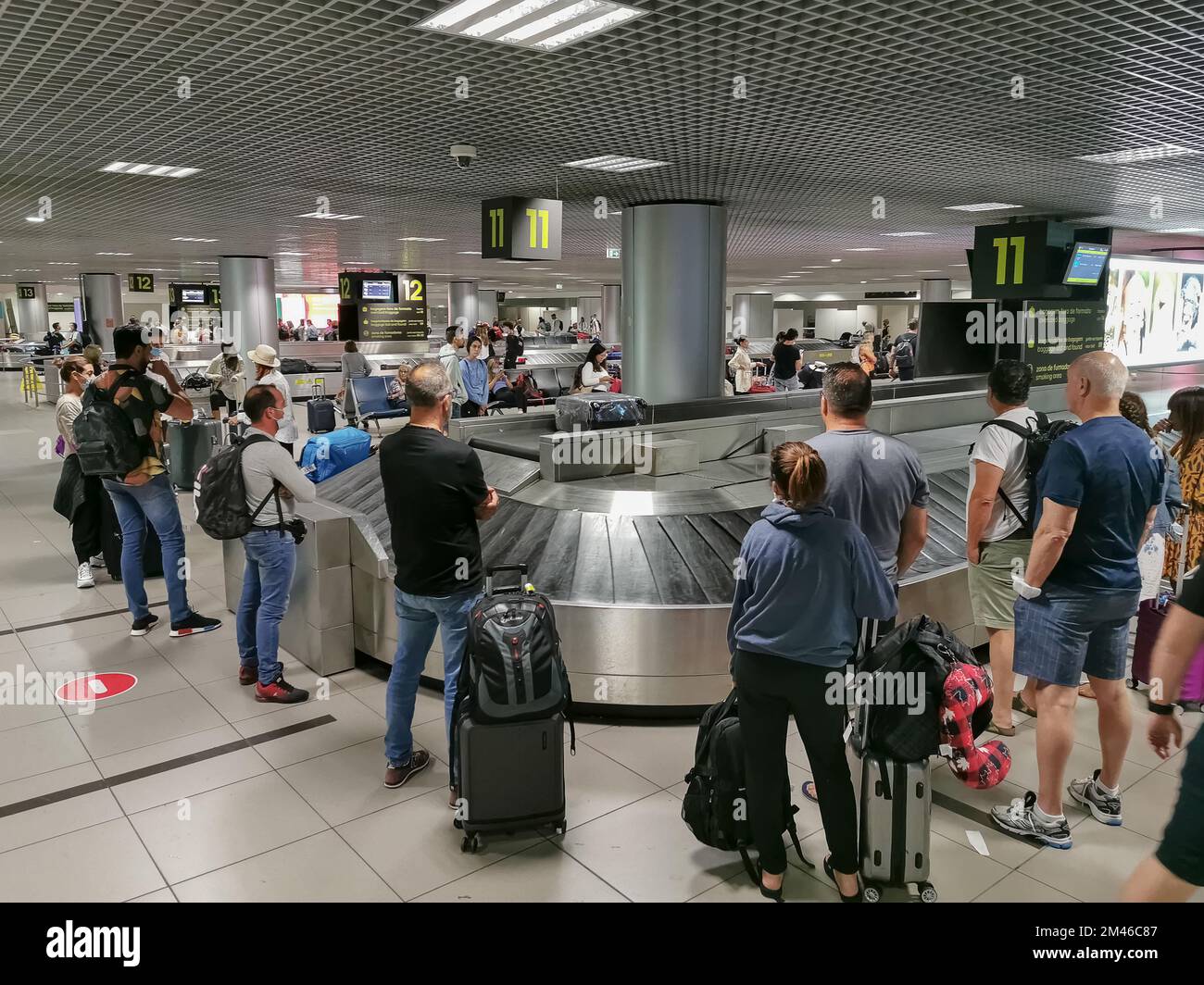 Lisbona Portogallo - 23 07 2022:00: Vista presso la zona di ritiro bagagli o l'area di ritiro bagagli nell'edificio del terminal dell'aeroporto di Lisbona, le persone in attesa del loro lugg Foto Stock