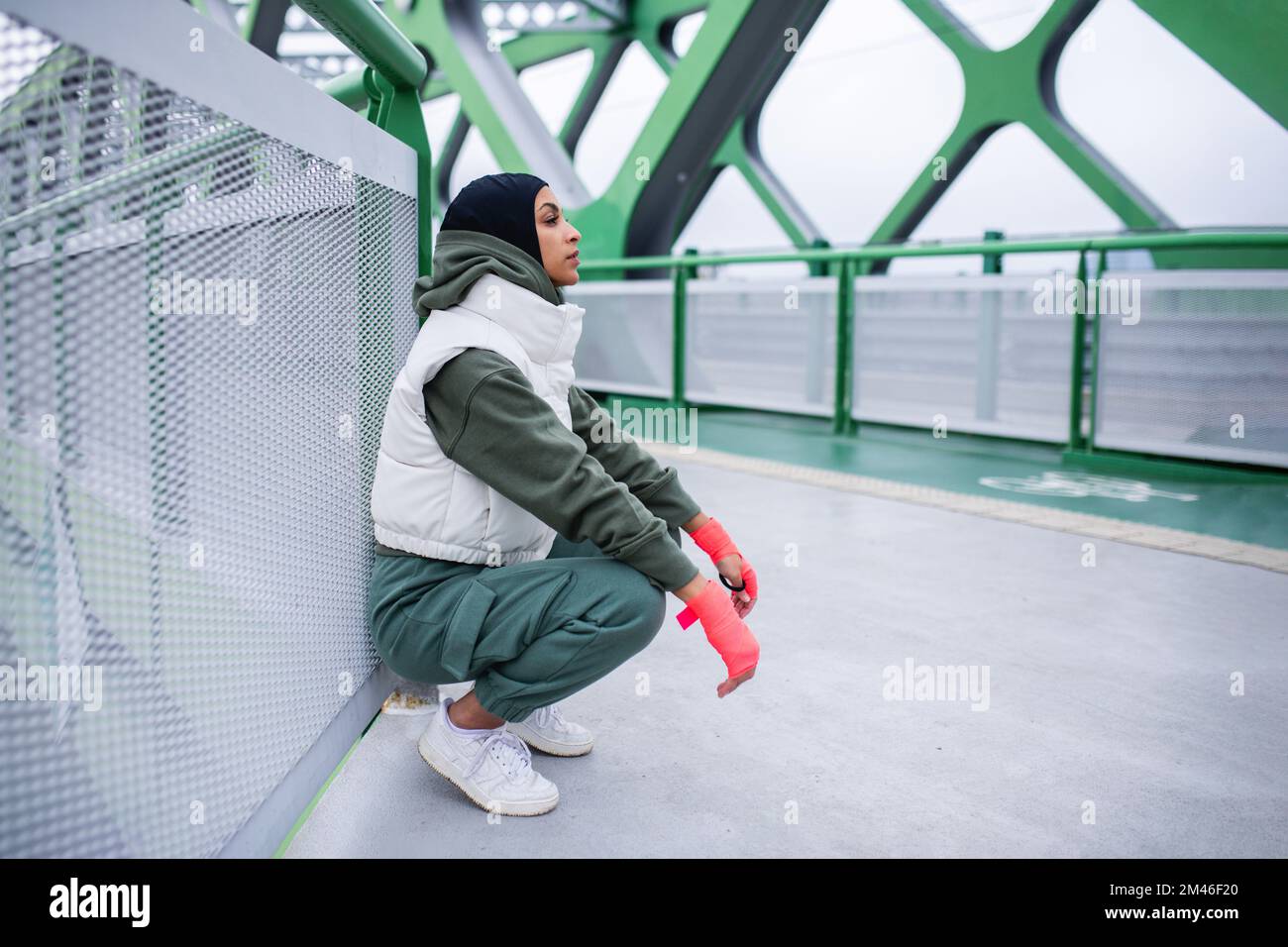 Giovane donna musulmana in pausa durante il jogging mattutino. Foto Stock