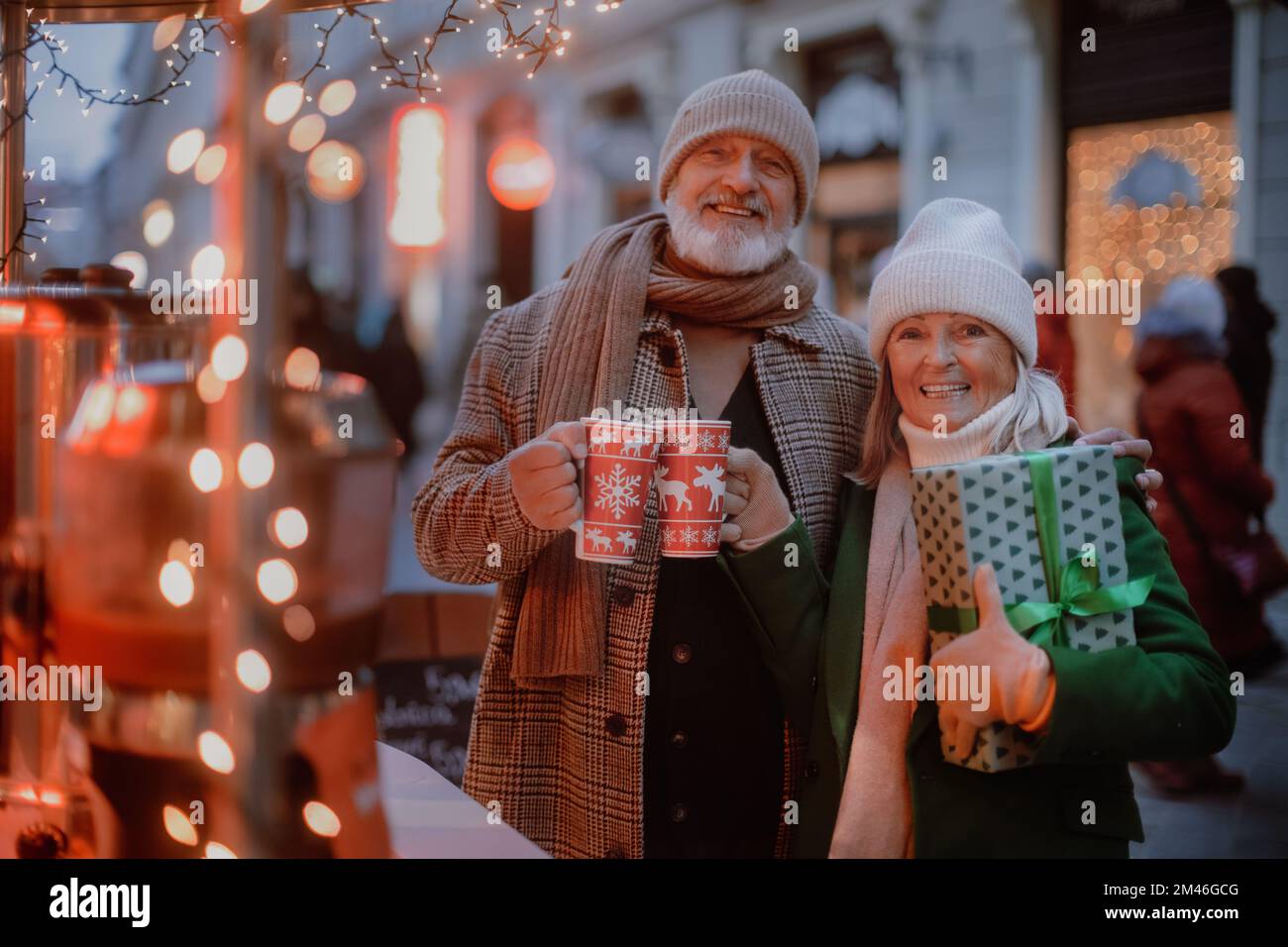 Coppia anziana felice godendo il mercato di natale, l'acquisto dei regali. Foto Stock