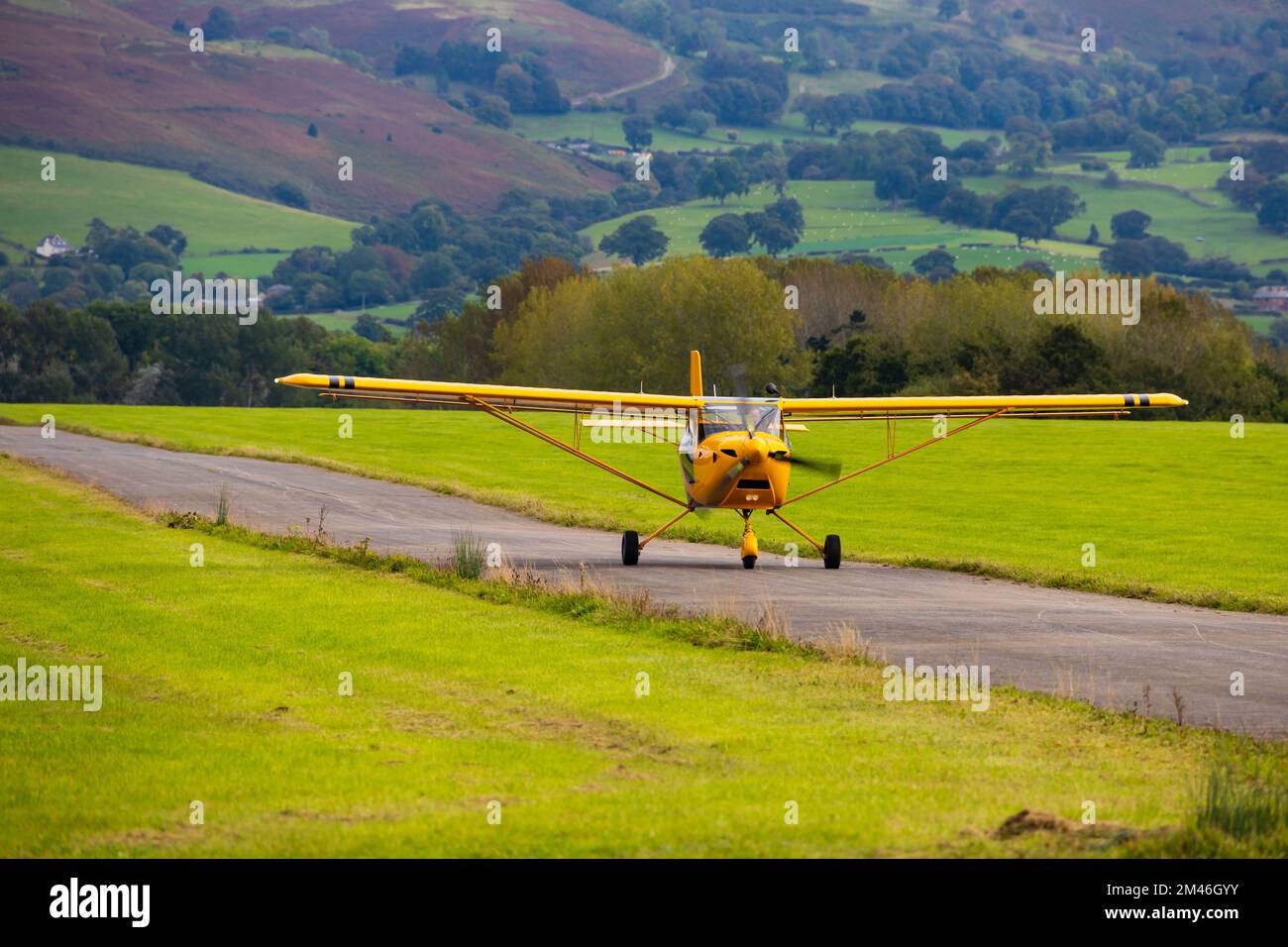 Velivolo giallo Eurofox in deltaplano atterrando a Lleweni Parc Airfield, Denbigh, Galles Foto Stock