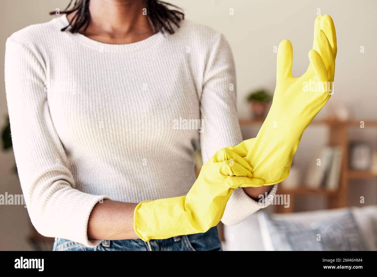 Pulizia, guanti di gomma e mani della donna in soggiorno per igiene, protezione e disinfezione. Sporcizia, polvere e batteri con la ragazza pulitore a casa Foto Stock