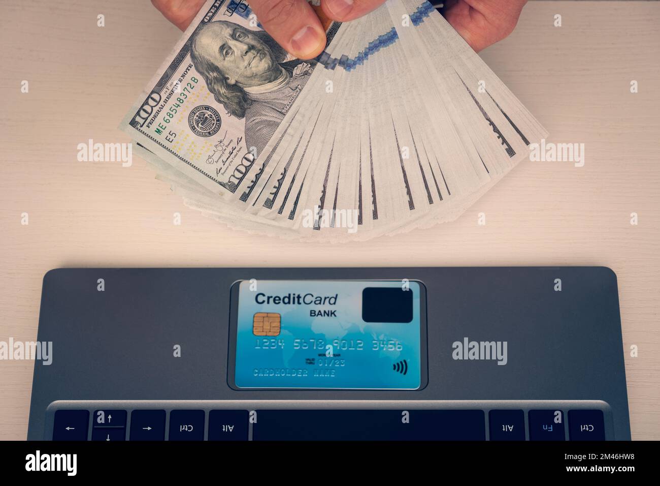 L'uomo tiene una fattura del dollaro per comprare in linea via il Internet, usando una carta di credito anziché il concetto di contanti. ritorno sull'investimento, lavoro online, sal del manager Foto Stock