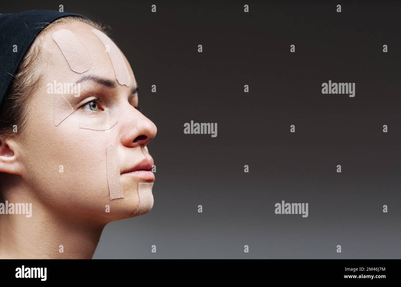 Cinesiologia facciale nastro sul viso femminile primo piano. Foto Stock
