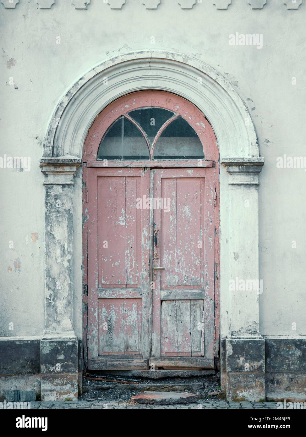 Antica porta d'ingresso dipinta in legno ad arco in antiche mura dell'edificio. Foto Stock