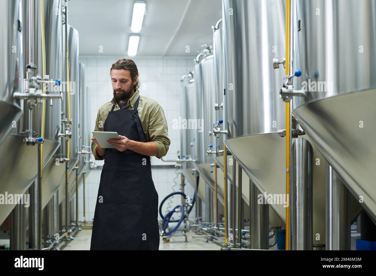 Responsabile del controllo del lavoro della birreria tramite l'applicazione su tablet digitale Foto Stock