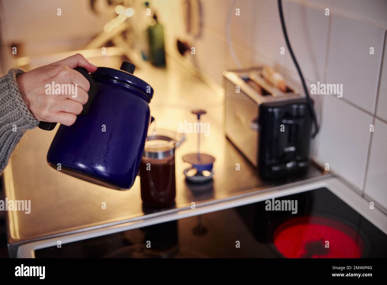 La donna la preparazione di caffè in cucina Foto Stock