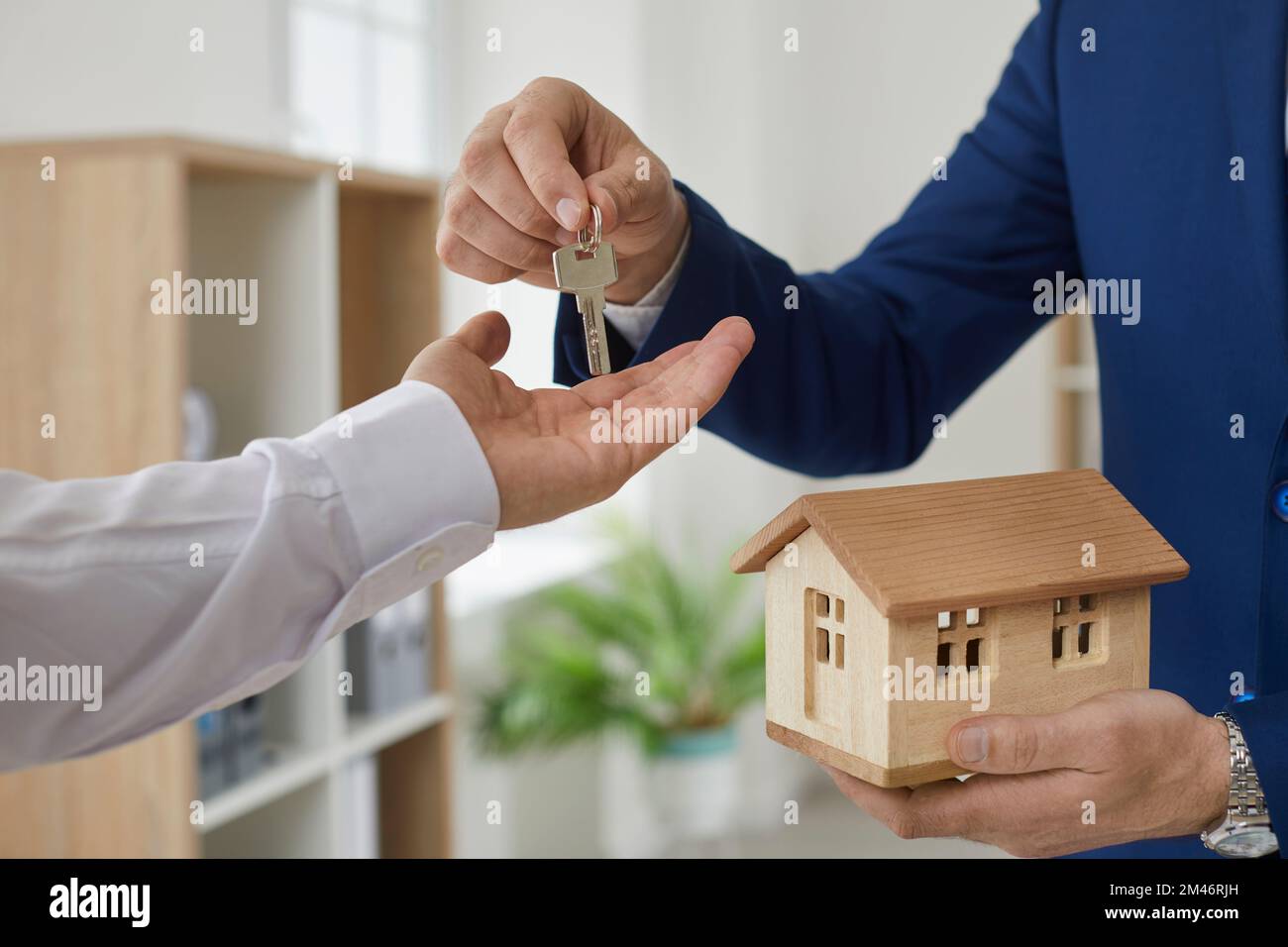 L'agente immobiliare consegna la chiave al cliente dopo la firma del contratto di acquisto a casa. Foto Stock