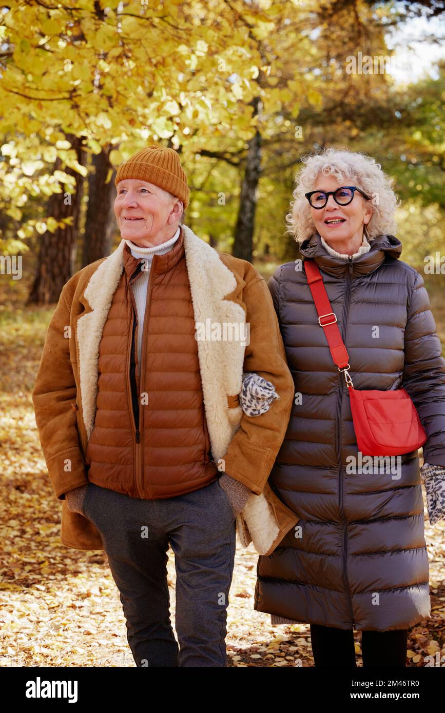 Coppia senior a piedi nel parco autunnale Foto Stock