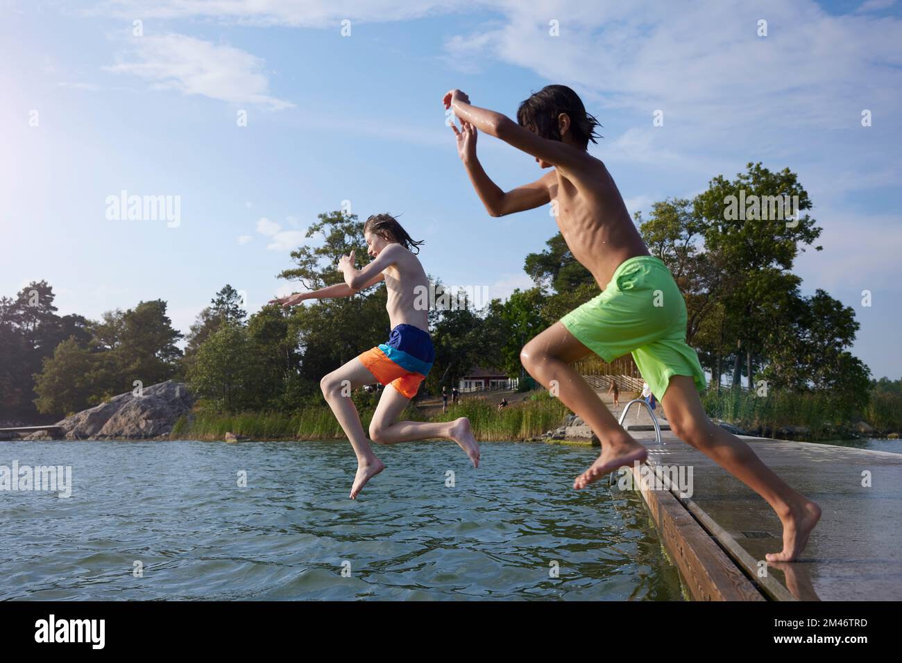 Ragazzi che saltano in acqua Foto Stock