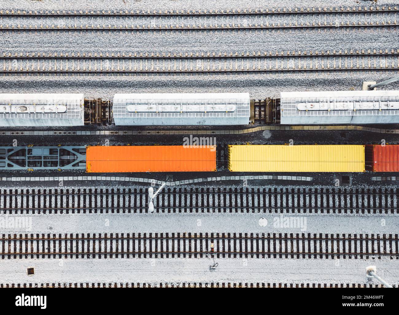 Vista dall'alto verso il basso carri colorati in piedi ancora parcheggiati sulle linee ferroviarie Foto Stock