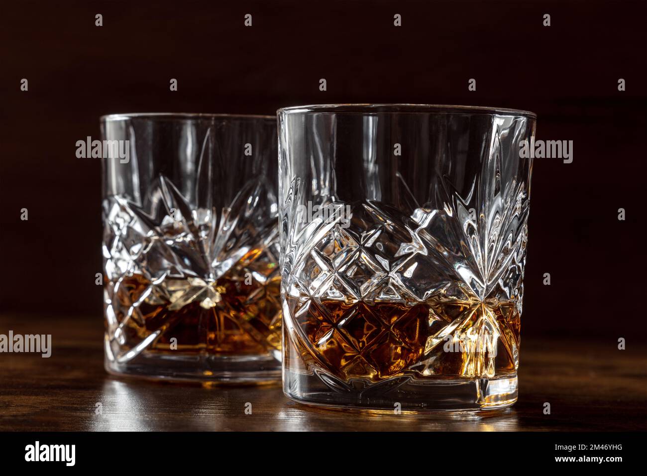 Whisky in bicchieri con ghiaccio. Whisky borbonico sulle rocce su sfondo scuro, bevande eleganti Foto Stock