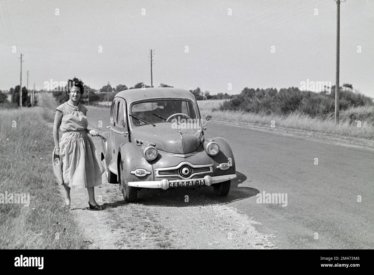 La giovane donna francese 1950s si pone davanti a una Panhard vintage Dyna X prodotta tra il 1948 e il 1954. Auto d'epoca fotografata in1955 Foto Stock