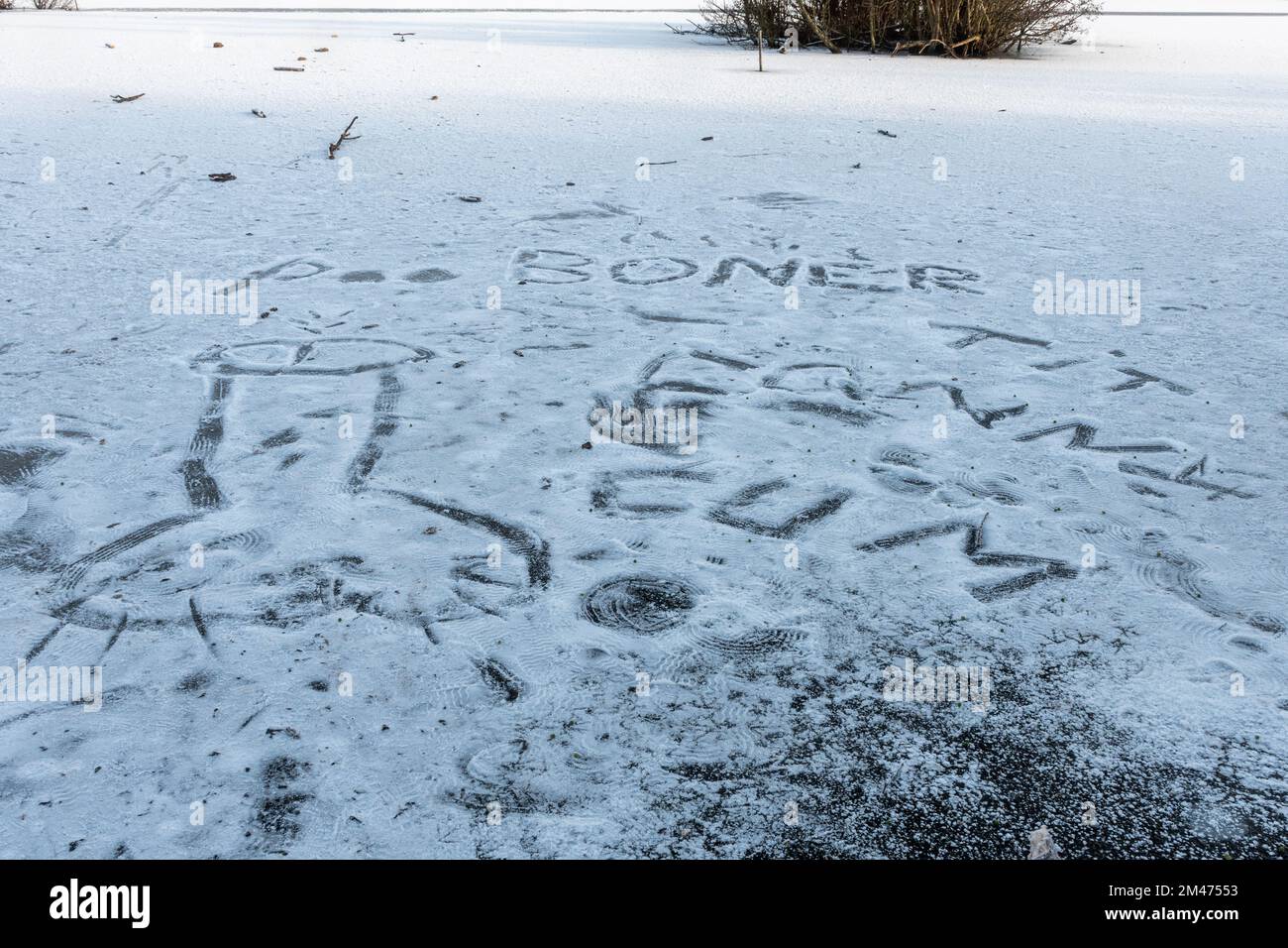 Stagno congelato con parole rude e immagini che mostrano alcune persone non stanno facendo attenzione avvertimenti di pericolo di camminare su laghi congelati, Regno Unito, dicembre 2022 Foto Stock