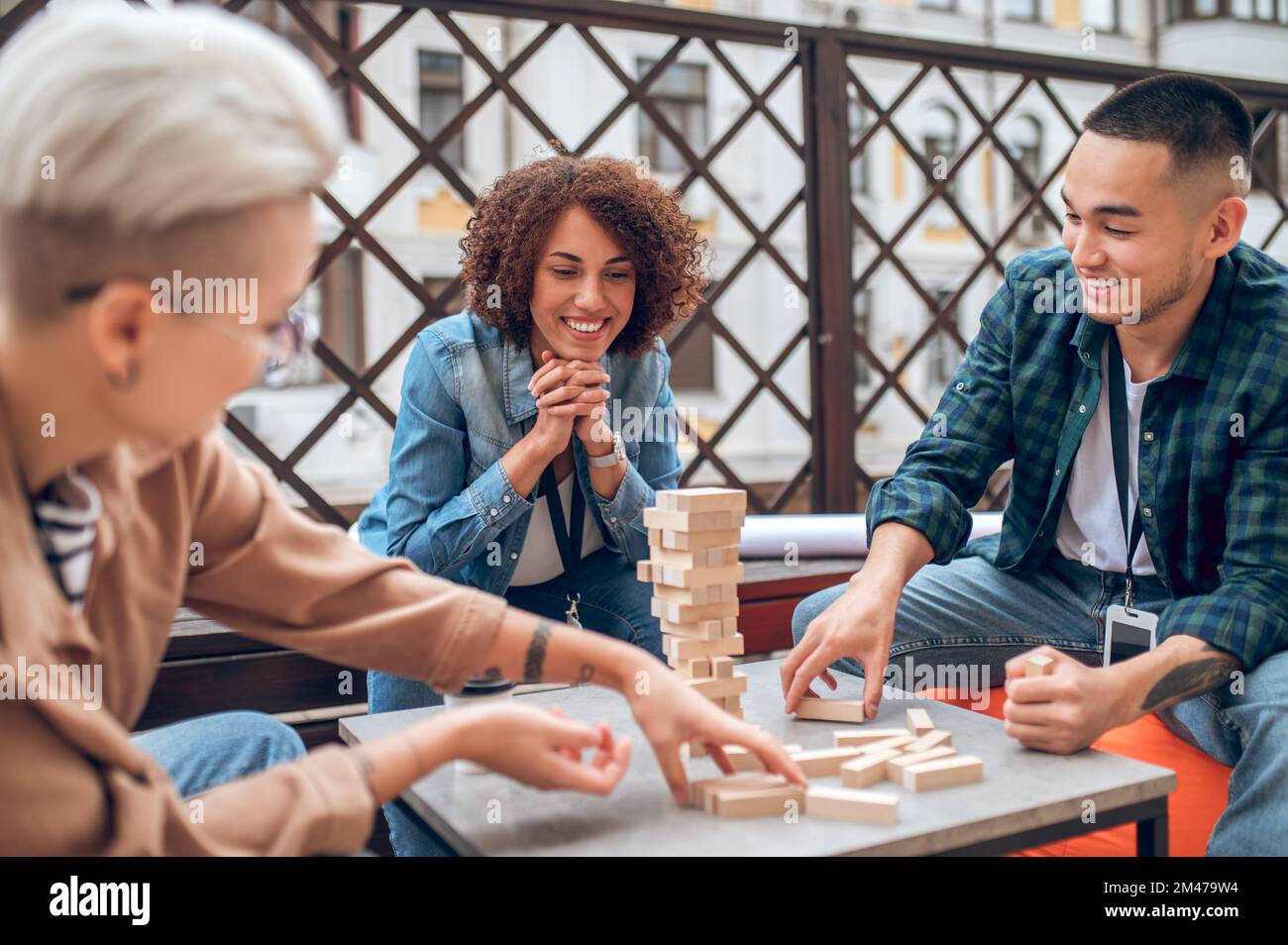 Un dipendente dell'azienda che osserva i suoi colleghi che giocano a un gioco da tavolo Foto Stock