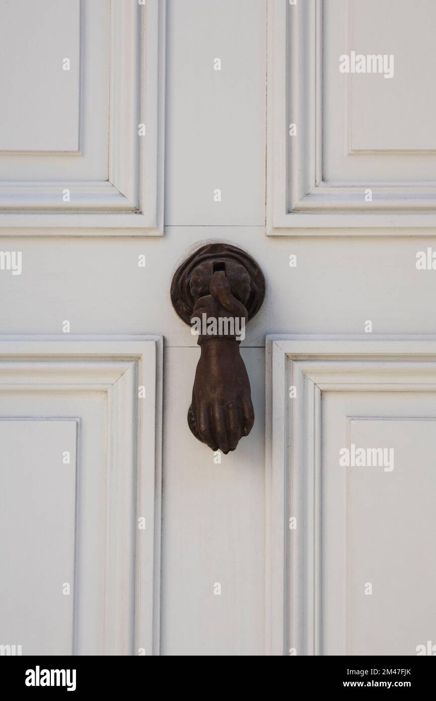 Battitappo nero su una porta di legno bianco. Foto Stock