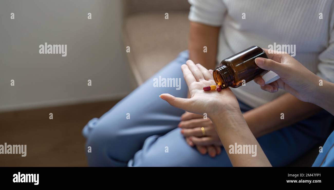 Operatore sanitario o caregiver che visita una donna anziana in casa, spiegando il dosaggio della medicina. Primo piano Foto Stock