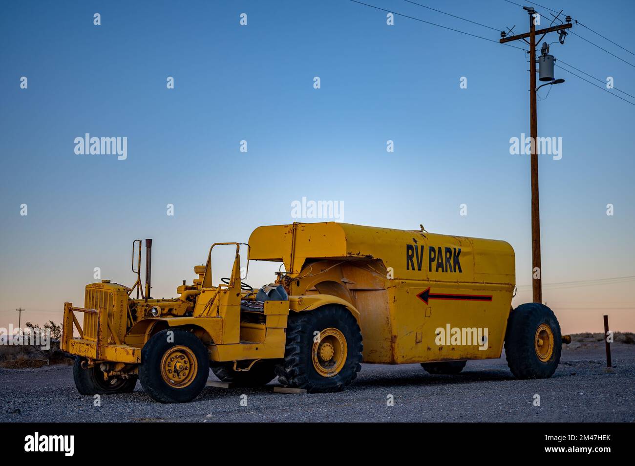 Trattore giallo che trasporta un rimorchio con un serbatoio di propano. Caterpillar serie DX10 1N 4x2. Viene abbandonato Foto Stock