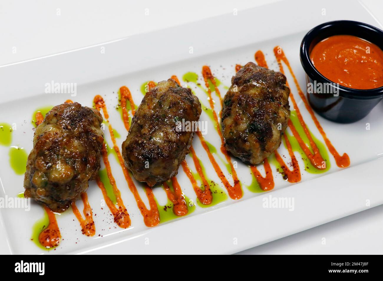 autentica cucina araba mediterranea, succosa carne di manzo o di agnello e kebab al formaggio con salsa harissa rossa speziata Foto Stock