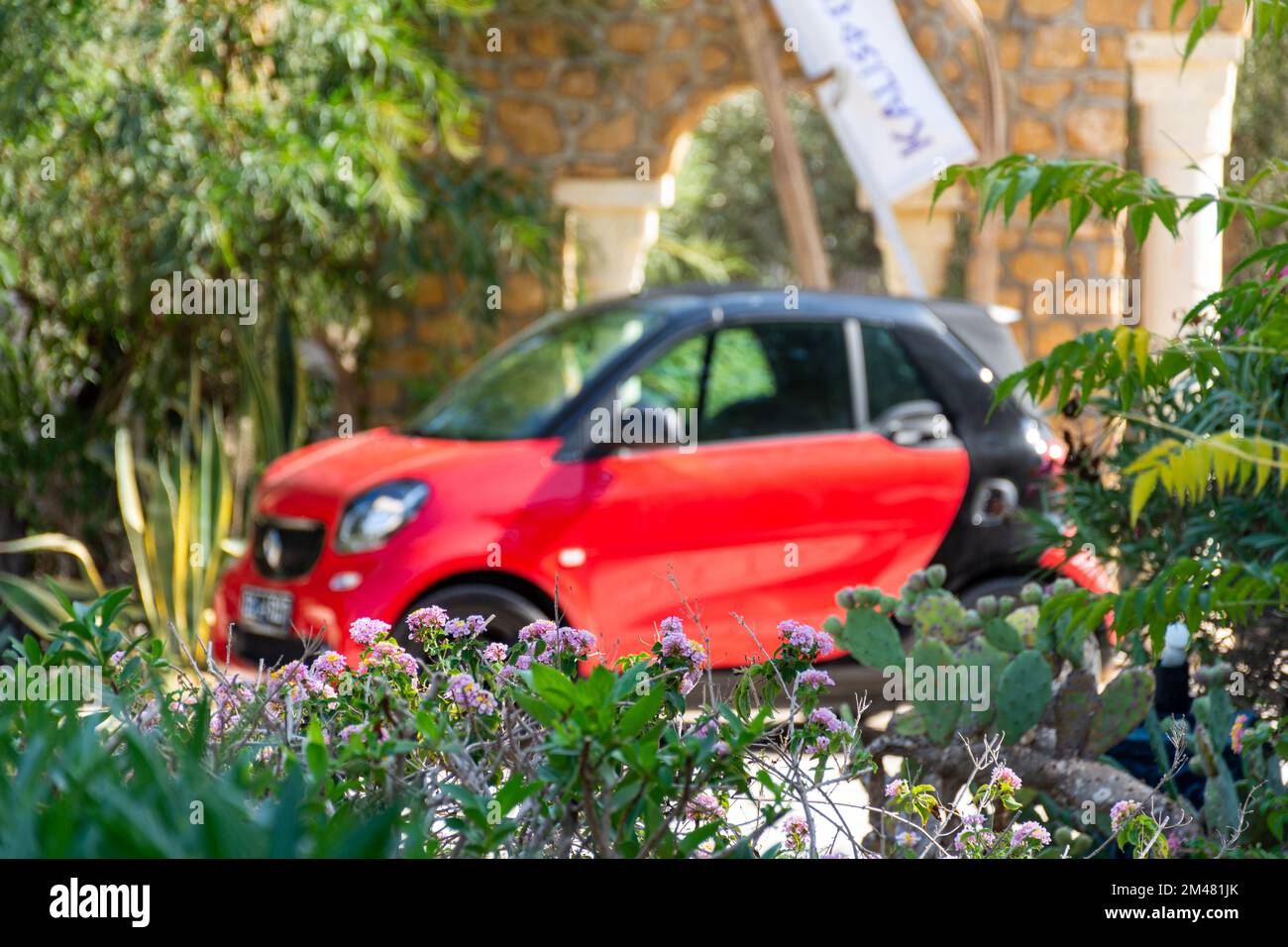 Una macchina rossa intelligente ForTwo nel parcheggio dell'hotel in una bella giornata di sole. Foto Stock
