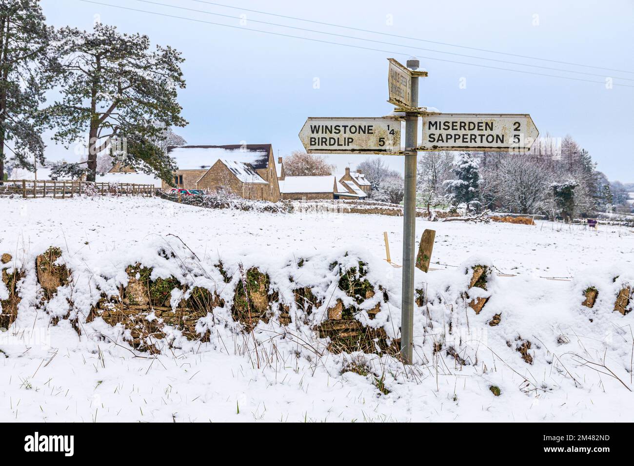 Un cartello stradale nella neve di inizio inverno vicino al villaggio Cotswold di Winstone, Gloucestershire, Inghilterra UK Foto Stock