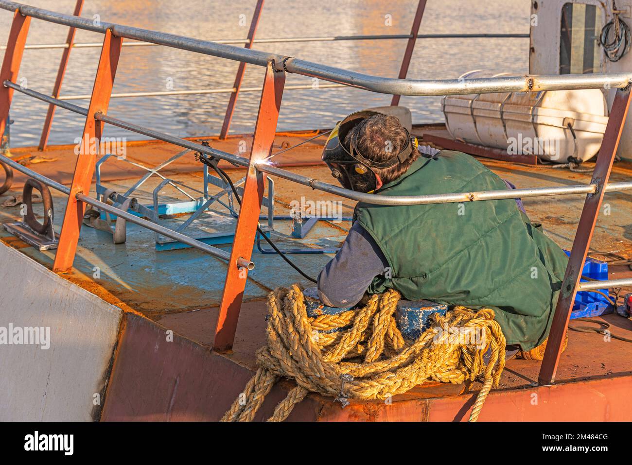 il saldatore sta saldando una costruzione di recinzione a bordo di una nave Foto Stock