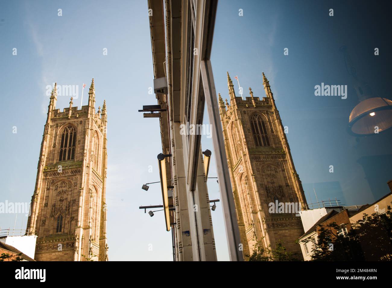 Derby Cathedral con il cielo blu riflesso nella vetrina dei negozi, derby, inghilterra, regno unito Foto Stock