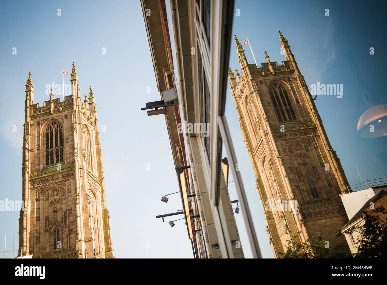 Derby Cathedral con il cielo blu riflesso nella vetrina dei negozi, derby, inghilterra, regno unito Foto Stock