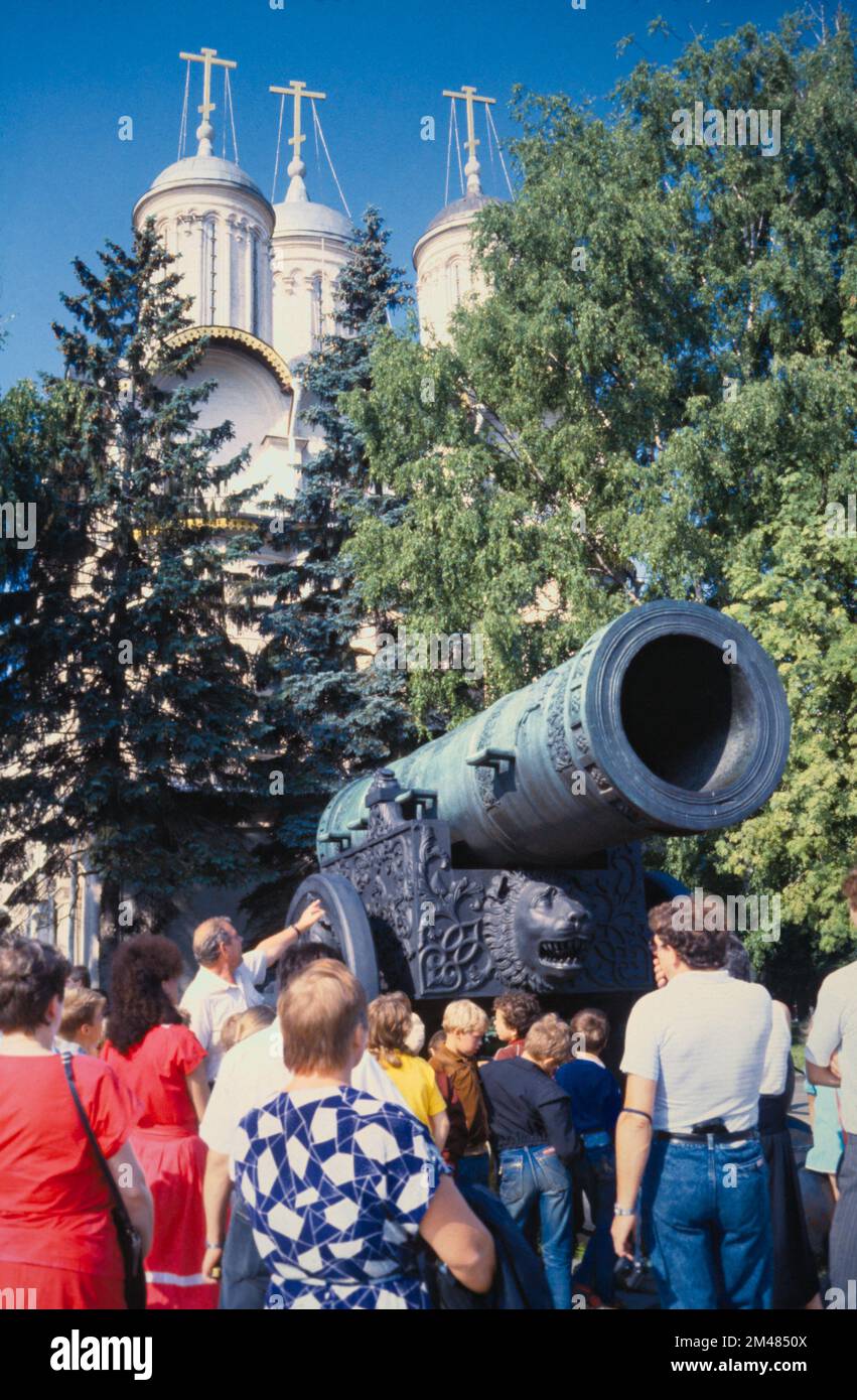 Immagine storica e archivistica di Una guida turistica e turisti che guardano il cannone dello zar di bronzo nei terreni del Cremlino di Mosca prima della dissoluzione dell'Unione Sovietica, 1990 Foto Stock