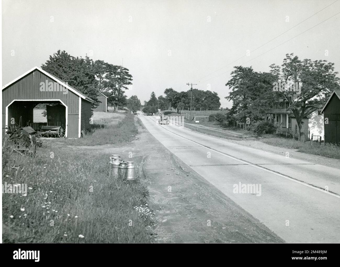 Lattine di latte in attesa di consegna. Didascalia originale: Lattine di latte in attesa di consegna sulla state Route 27, Maryland. Stato: Maryland. Località: State Route 27. Foto Stock