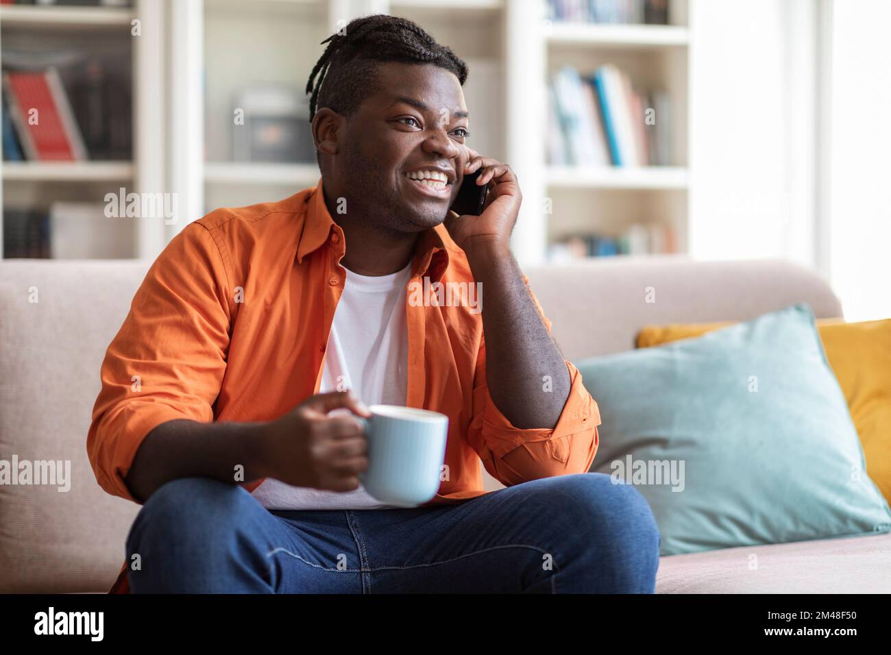 Cool afro americano uomo bere caffè e parlare al telefono Foto Stock