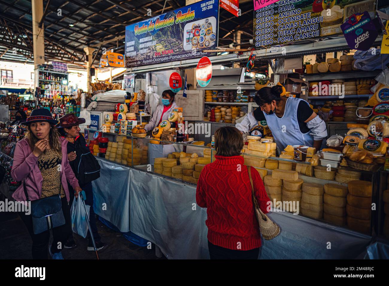 La gente che acquista formaggio e generi alimentari dai negozi e mercati nel centro di Cusco, Perù Foto Stock