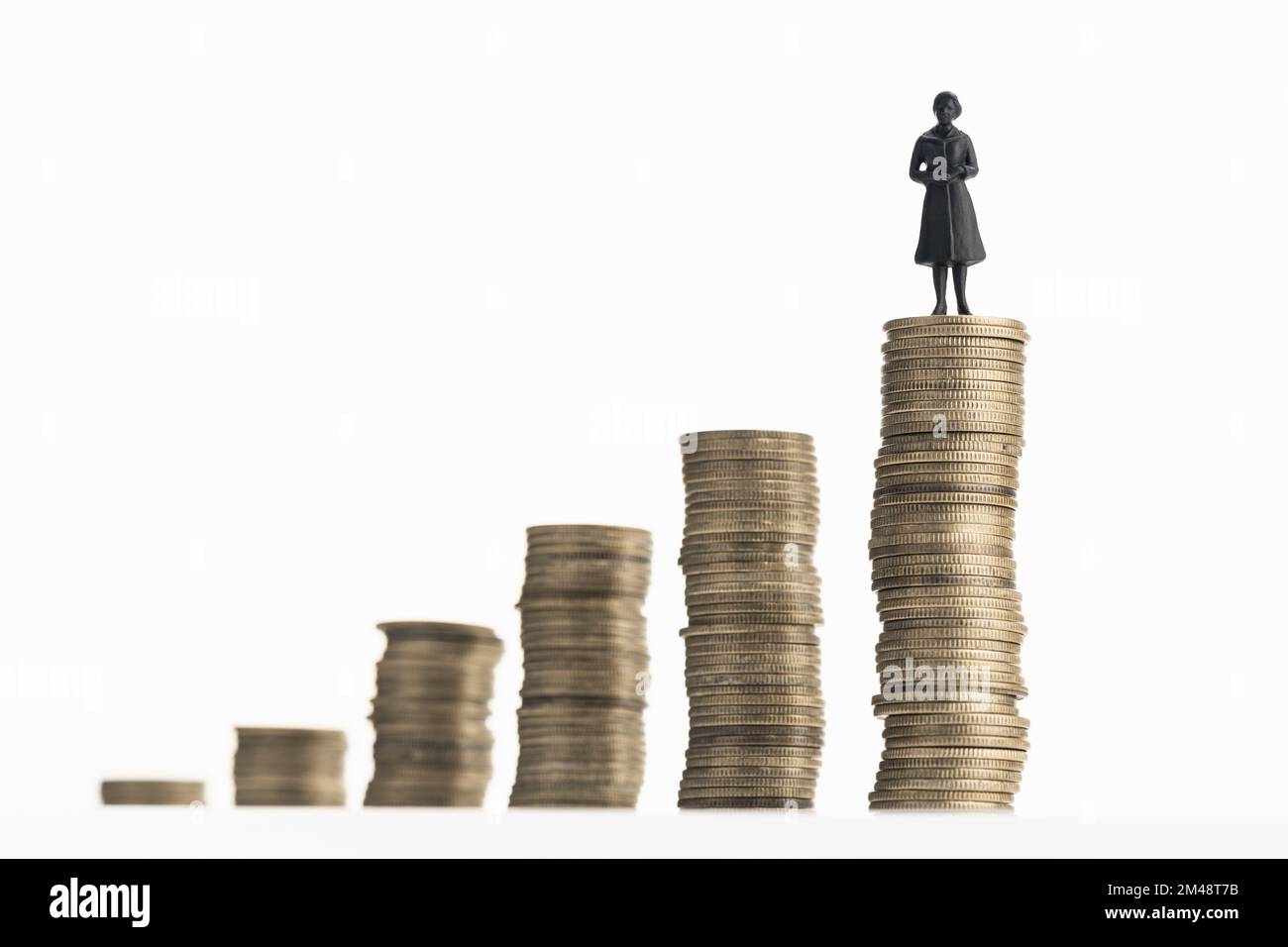 Donna in piedi su una pila di monete in crescita. Ricchezza, risparmio, concetto di ricchezza. Spazio di copia Foto Stock
