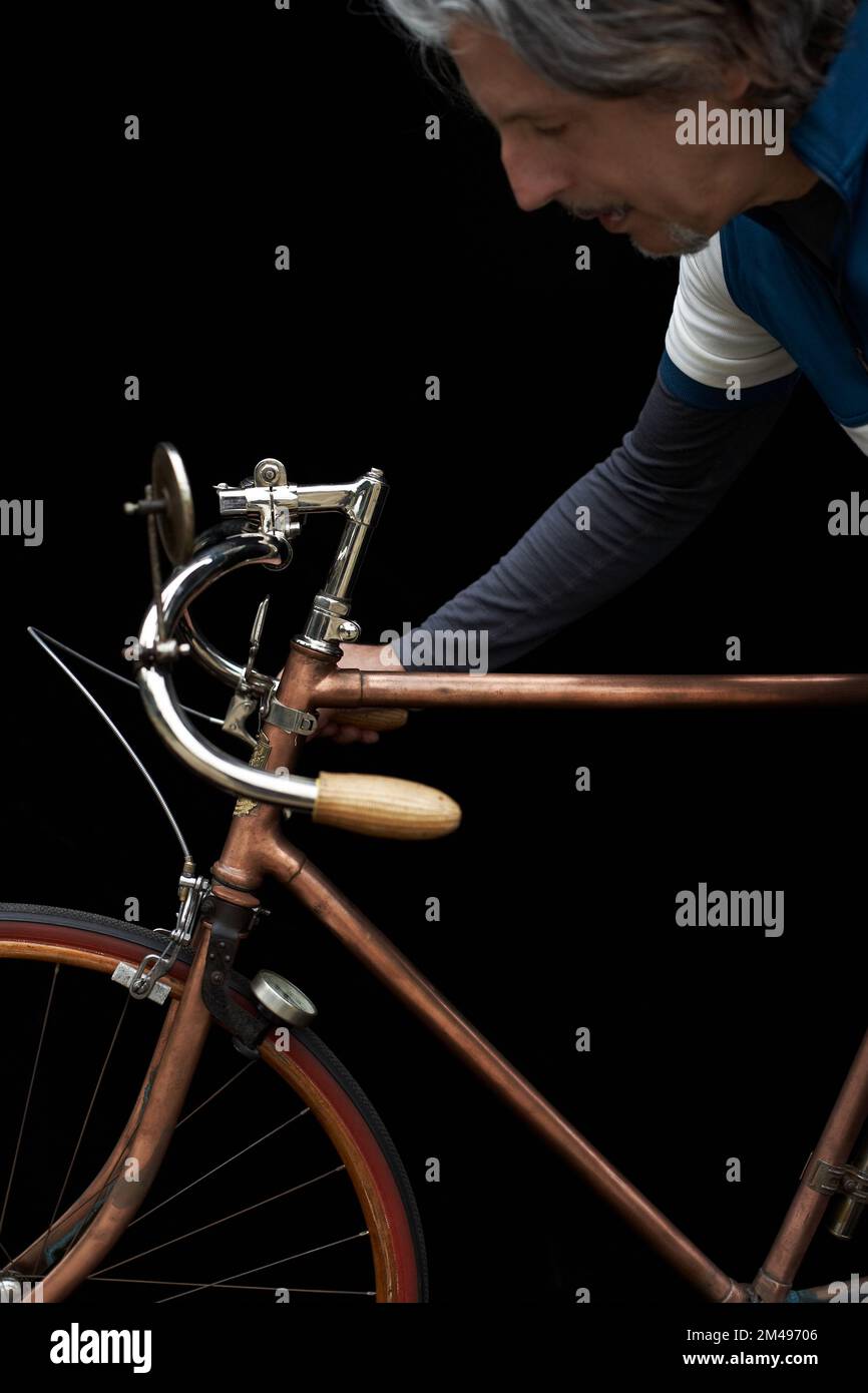 collezionista di biciclette con bici retrò d'epoca e sfondo nero Foto Stock