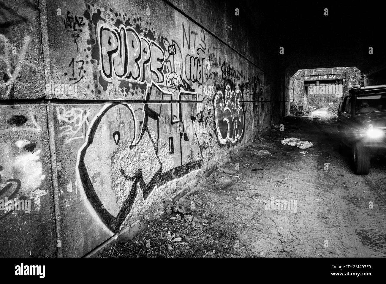 Muro graffiti e volate ribaltando all'interno di un tunnel di strada abbandonato. Foto Stock