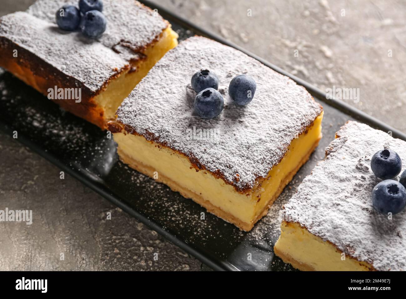 Torta al formaggio con mirtilli su un tavolo di grunge scuro Foto Stock