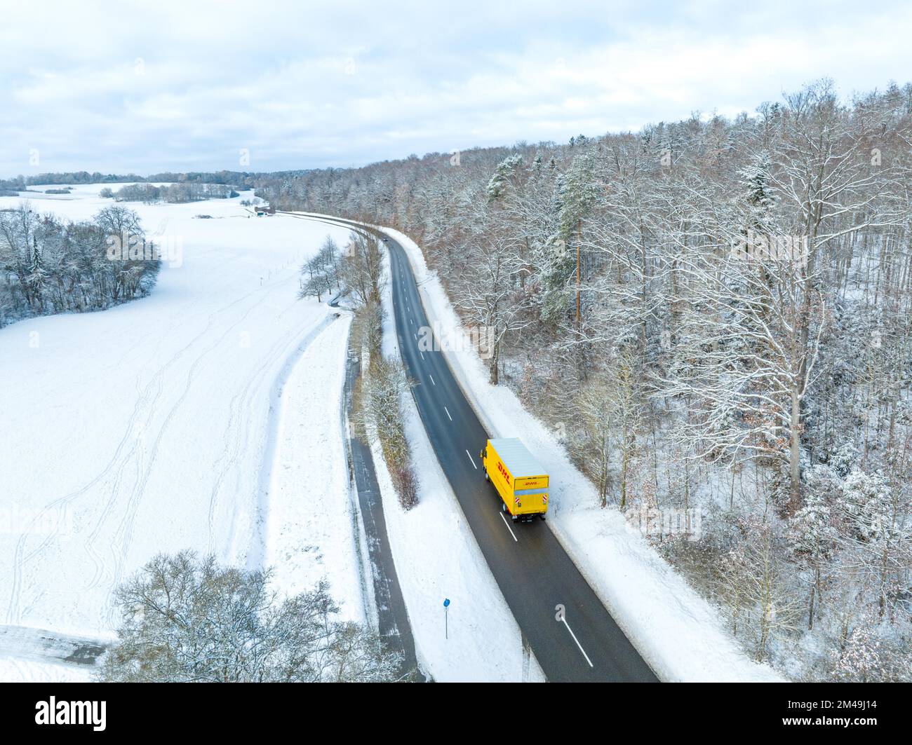 DHL auto sulla strada invernale ai margini della foresta, Gechingen, Foresta Nera, Germania Foto Stock