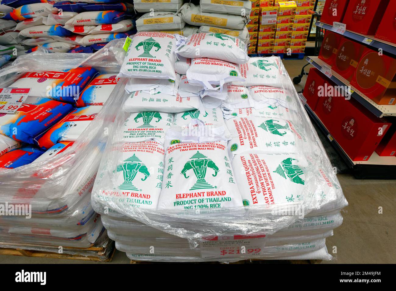 Sacchi di tre Elephant marchio Jasmine riso, Thai Hom Mali riso su un pallet in un negozio di alimentari asiatico. Foto Stock