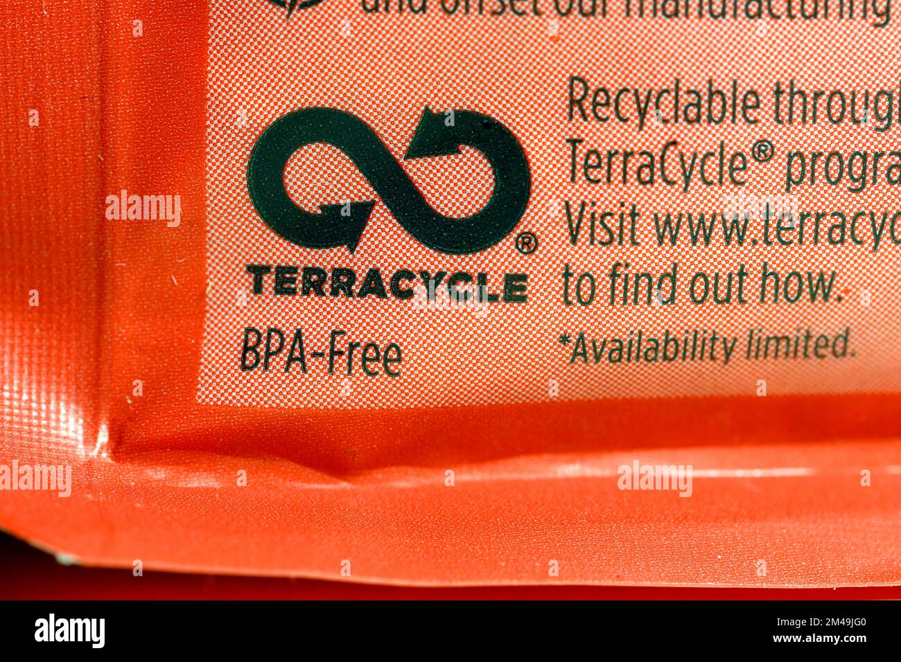 Il simbolo TerraCycle sul retro di un sacchetto di plastica per alimenti con una dichiarazione di non responsabilità 'disponibilità limitata'. Foto Stock