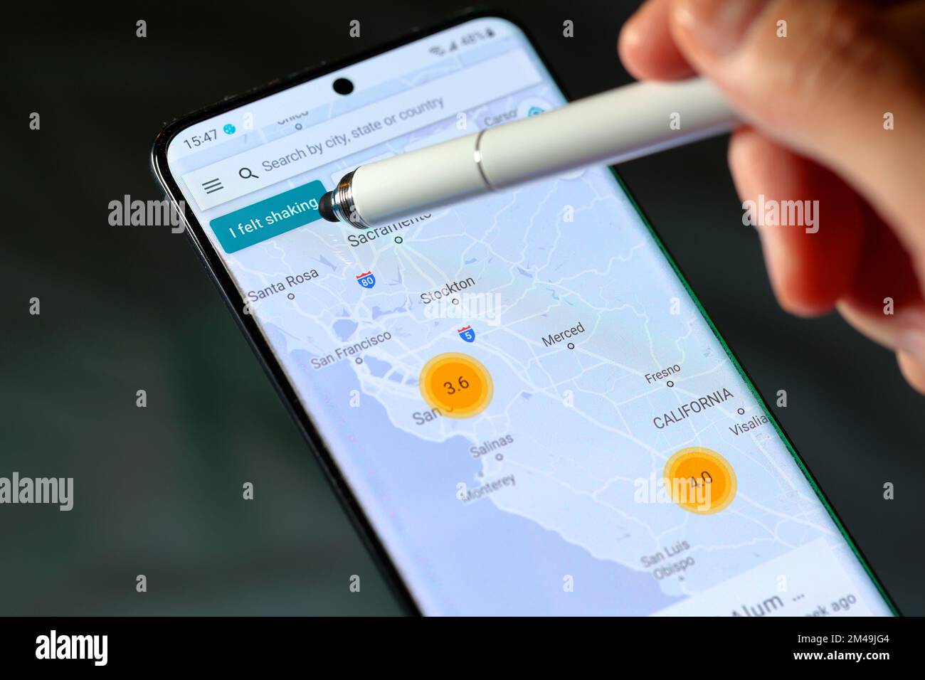 Uno stilo indica il pulsante "i felt shaking" sull'app MyShake Earthquake di UC Berkeley Seismologic Lab. Foto Stock