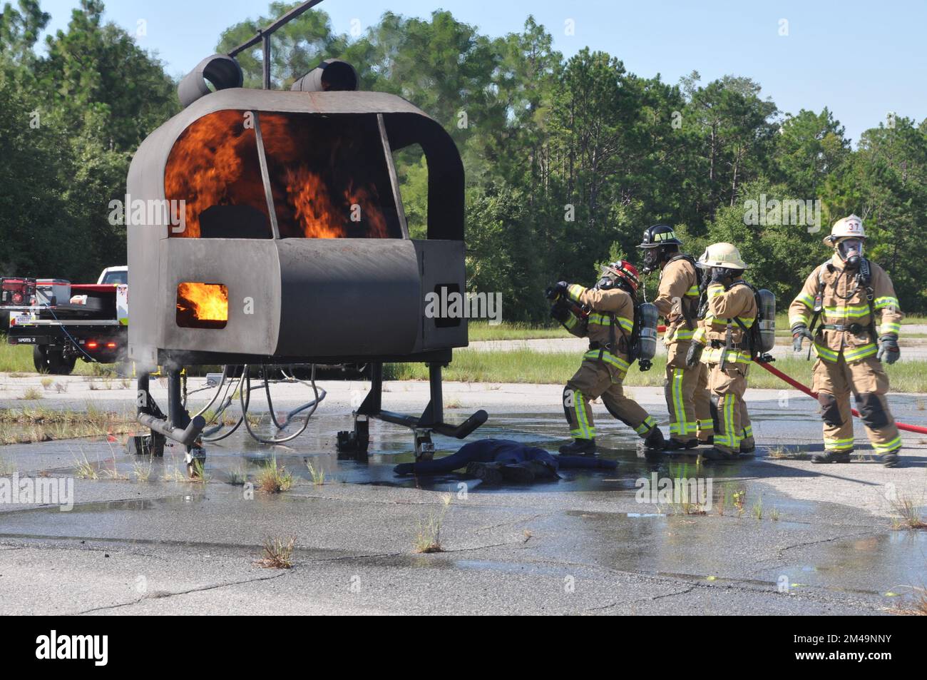 I vigili del fuoco della 908th Civil Engineer Squadron del 908th Airlift Wing si preparano a estinguere un incendio mentre i vigili del fuoco della Fort Benning Fire Department osservano durante un esercizio di addestramento con un addestratore di elicotteri antincendio del 4 agosto 2022, a Fort Benning Georgia. I vigili del fuoco 908th hanno collaborato con il Dipartimento dei vigili del fuoco di Fort Benning per condurre la loro prima formazione congiunta sull'interoperabilità e per utilizzare l'addestratore di elicotteri per accelerare il loro addestramento in preparazione alla remissione 908 AW all'unità di addestramento formale dell'aeronautica militare per l'elicottero MH-139A Grey Wolf. (STATI UNITI Forza pneumatica p Foto Stock