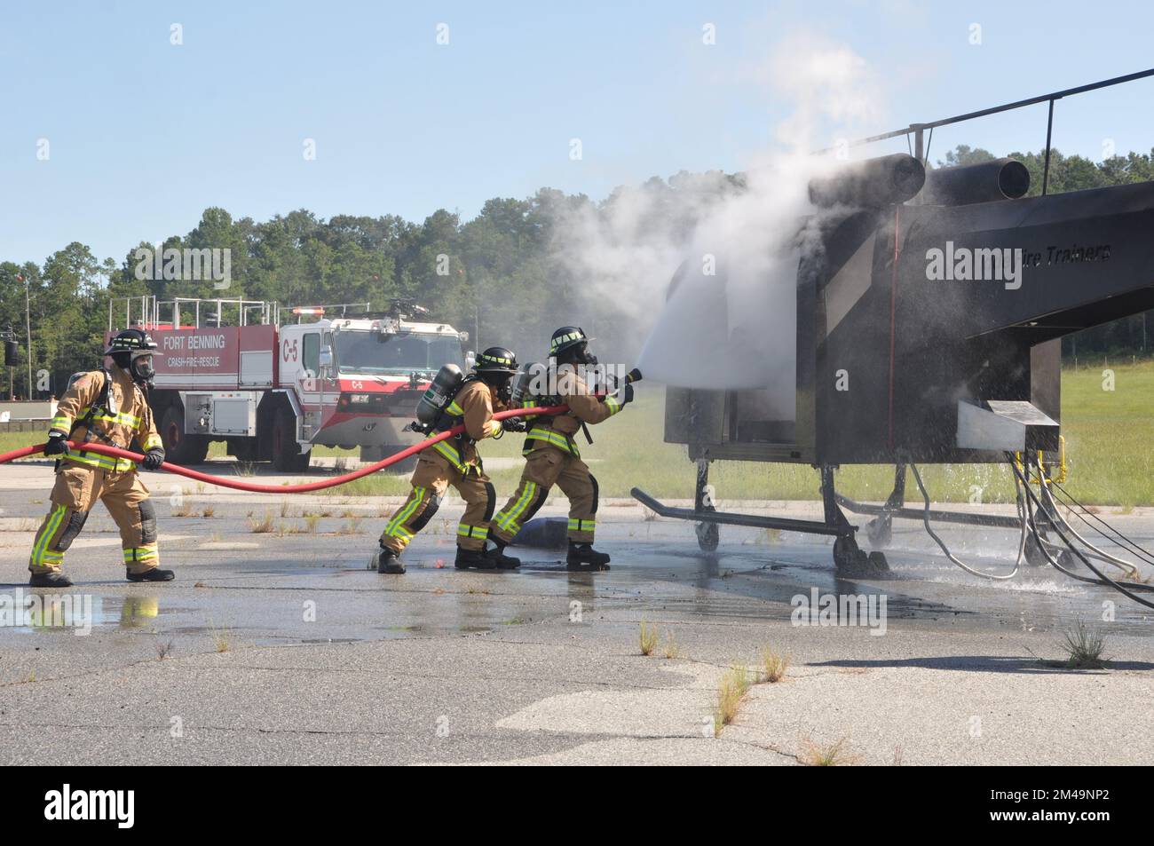 I vigili del fuoco del 908th° Squadron, ingegnere civile dell'Ala dell'Airlift 908th, estinguono un incendio mentre i vigili del fuoco del Fort Benning Fire Department osservano durante un esercizio di addestramento con un addestratore di elicotteri antincendio del 4 agosto 2022, a Fort Benning Georgia. I vigili del fuoco 908th hanno collaborato con il Dipartimento dei vigili del fuoco di Fort Benning per condurre la loro prima formazione congiunta sull'interoperabilità e per utilizzare l'addestratore di elicotteri per accelerare il loro addestramento in preparazione alla remissione 908 AW all'unità di addestramento formale dell'aeronautica militare per l'elicottero MH-139A Grey Wolf. (STATI UNITI Foto Air Force di Bra Foto Stock