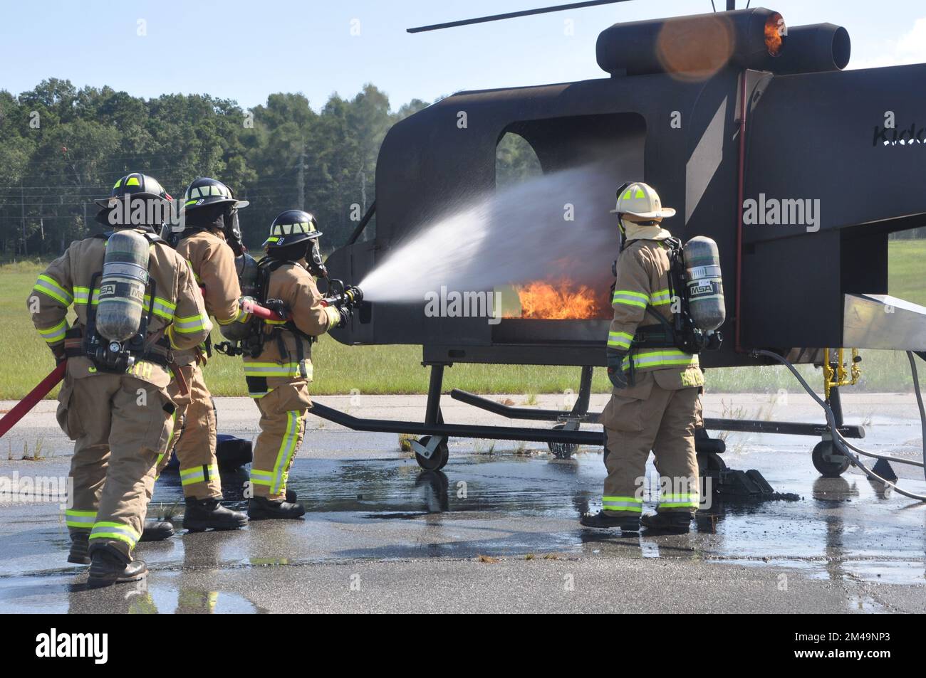 I vigili del fuoco del 908th° Squadron, ingegnere civile dell'Ala dell'Airlift 908th, estinguono un incendio mentre i vigili del fuoco del Fort Benning Fire Department osservano durante un esercizio di addestramento con un addestratore di elicotteri antincendio del 4 agosto 2022, a Fort Benning Georgia. I vigili del fuoco 908th hanno collaborato con il Dipartimento dei vigili del fuoco di Fort Benning per condurre la loro prima formazione congiunta sull'interoperabilità e per utilizzare l'addestratore di elicotteri per accelerare il loro addestramento in preparazione alla remissione 908 AW all'unità di addestramento formale dell'aeronautica militare per l'elicottero MH-139A Grey Wolf. (STATI UNITI Foto Air Force di Bra Foto Stock