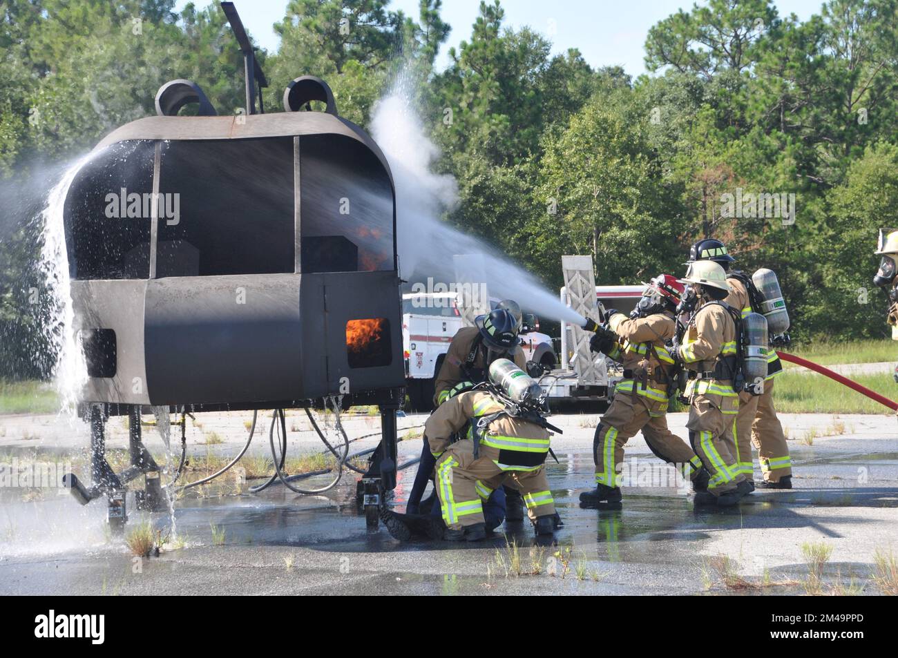 I vigili del fuoco della 908th Civil Engineer Squadron del 908th Airlift Wing salvano una vittima simulata mentre altri estinguono un incendio mentre i vigili del fuoco della Fort Benning Fire Department osservano durante un esercizio di addestramento con un addestratore di elicotteri antincendio del 4 agosto 2022, a Fort Benning Georgia. I vigili del fuoco 908th hanno collaborato con il Dipartimento dei vigili del fuoco di Fort Benning per condurre la loro prima formazione congiunta sull'interoperabilità e per utilizzare l'addestratore di elicotteri per accelerare il loro addestramento in preparazione alla remissione AW del 908 all'unità di addestramento formale dell'aeronautica per il lupo grigio MH-139A h. Foto Stock