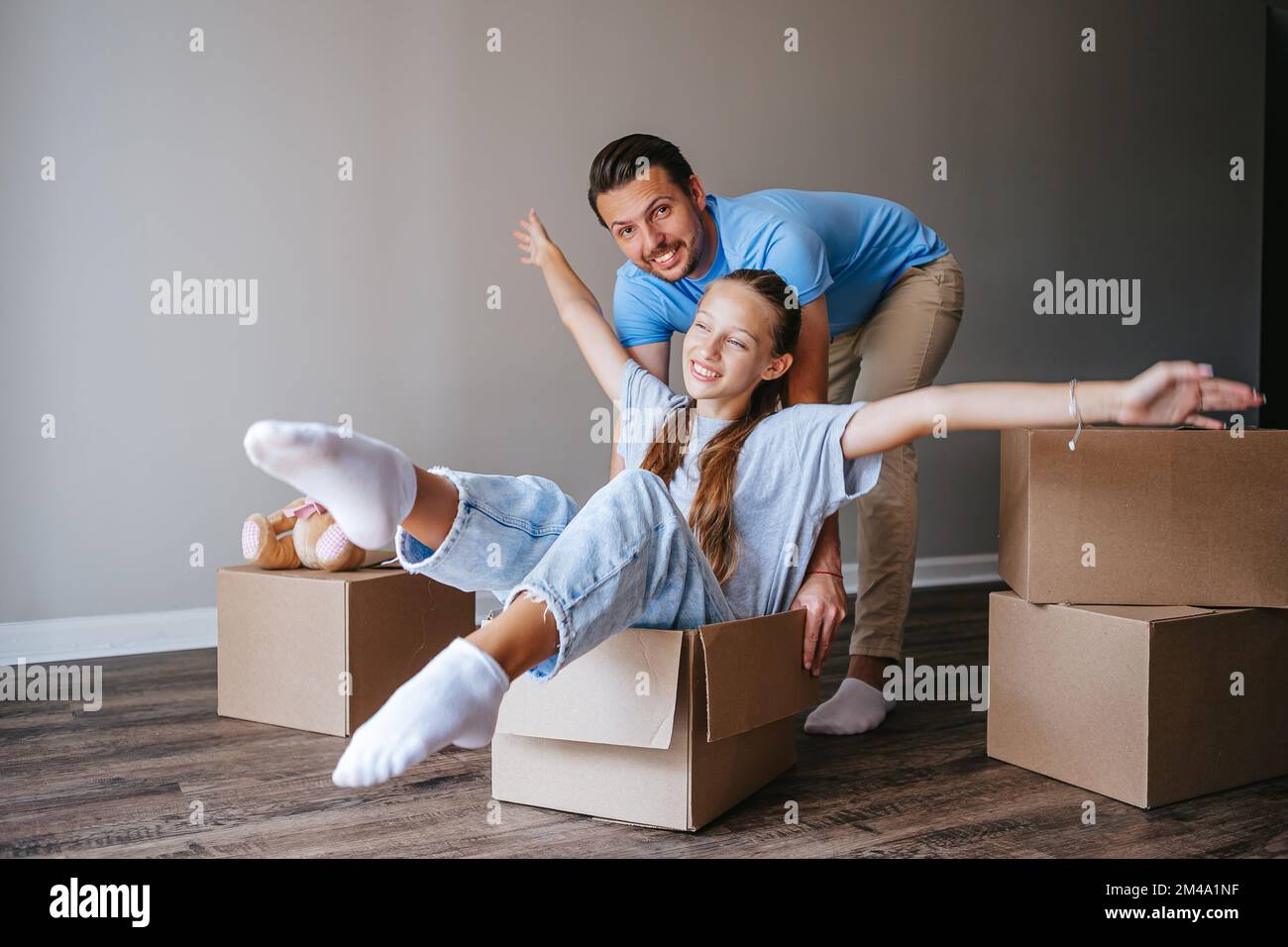 La famiglia si diverte a muoversi nella loro nuova casa Foto Stock