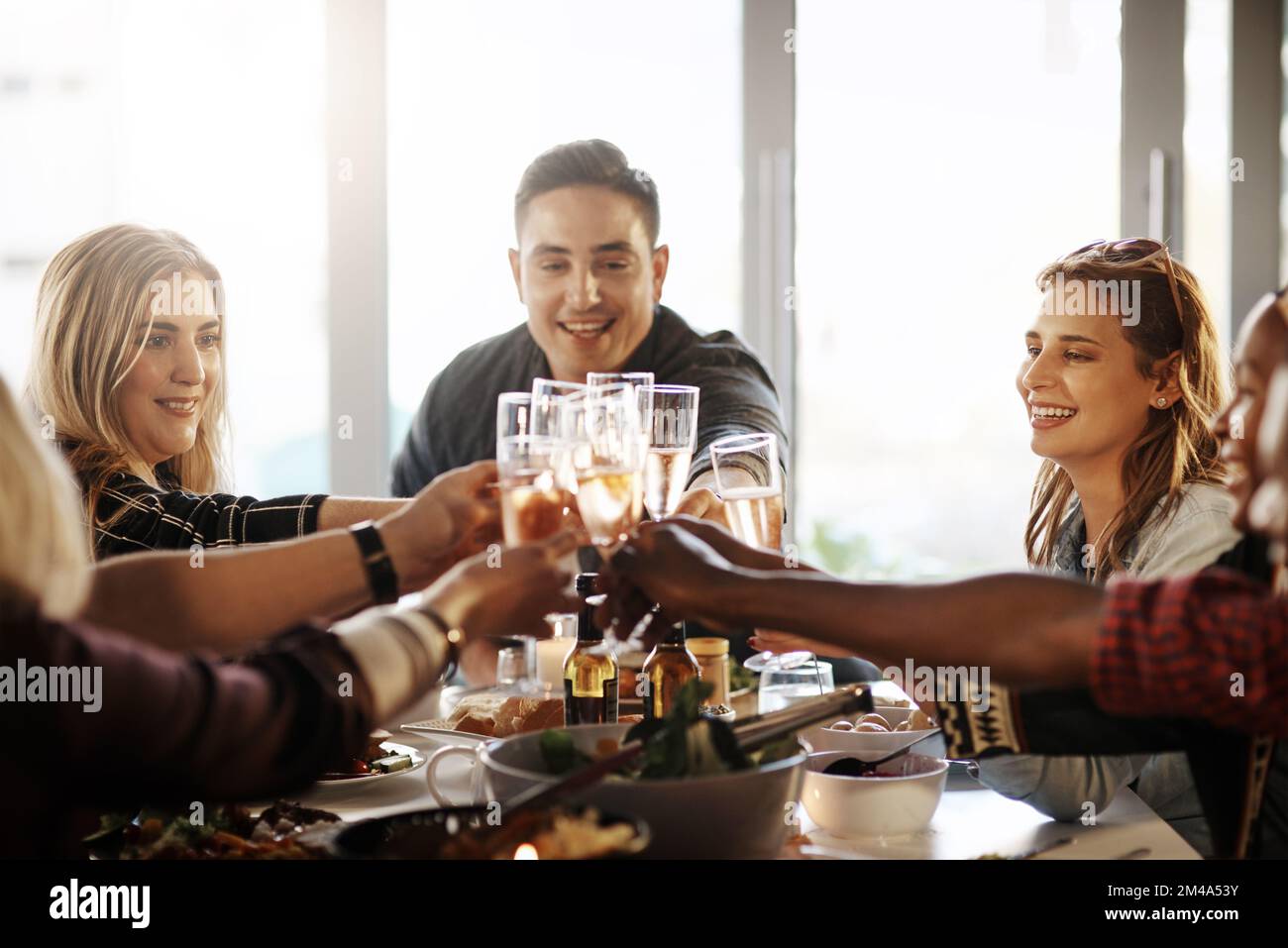 I ricordi migliori sono quelli condivisi con gli amici. un gruppo di giovani amici che fanno un brindisi a una cena. Foto Stock